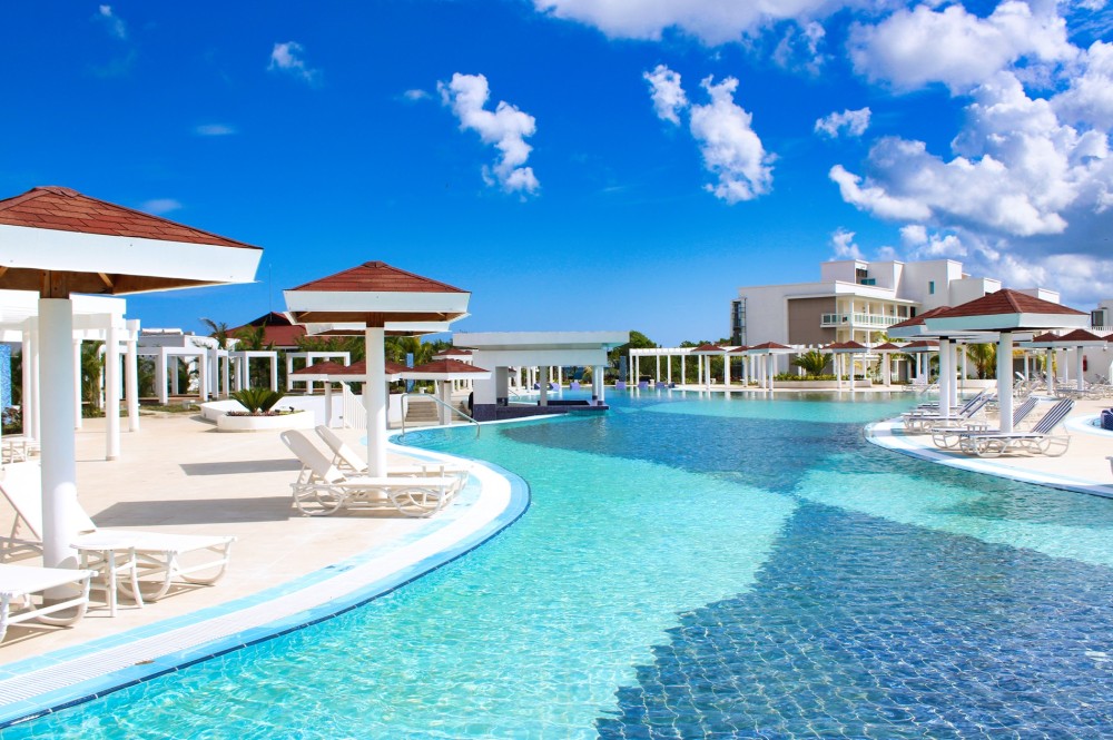 Zona de la piscina exterior del Hotel Gran Muthu Ensenada Beach de Guardalavaca, Holguín, Cuba: un complejo de cinco estrellas con todo incluido rodeado de vistas tropicales.